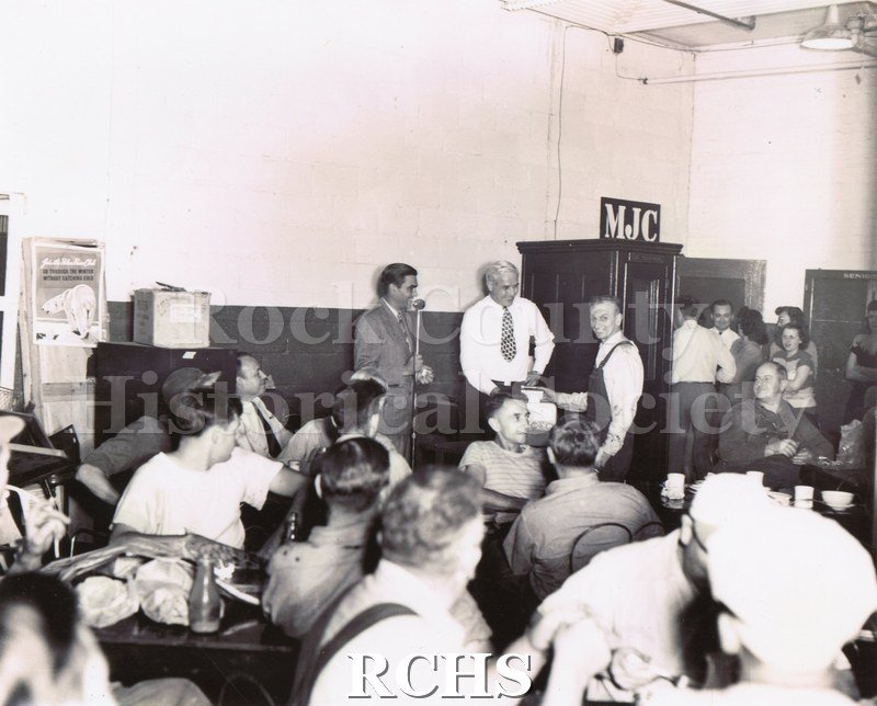 Black and white portrait of Clarence Dittmer receiving a portable radio for his entry into the GM "My Job and Why I Like It" corporate competition in 1947.