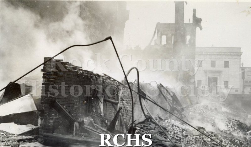Black and white photograph of the aftermath of a large fire on Milwaukee Street in downtown Janesville.