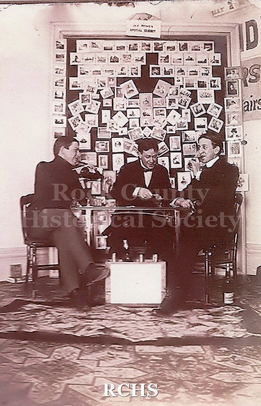 Black and white photograph of Charles Tallman, Stanley Tallman, and George Kemp Tallman in the drawing room of the Lincoln-Tallman House.