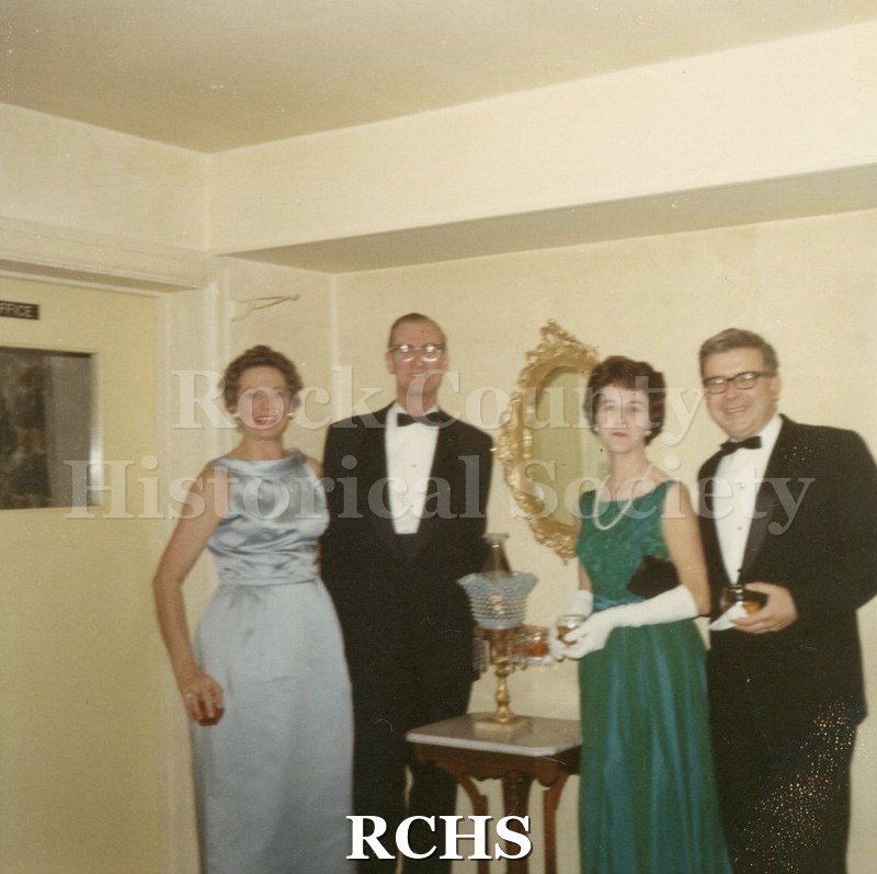 Color photo of Mr. and Mrs. John Hough and Mr. and Mrs. Don Doman standing beside a table.
