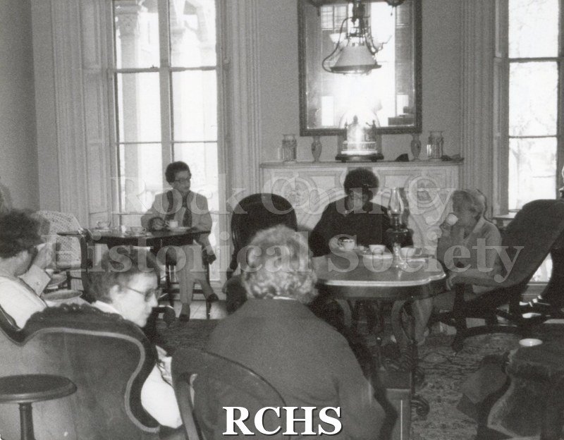 Black and white photograph of several women sitting in the Tallman House.