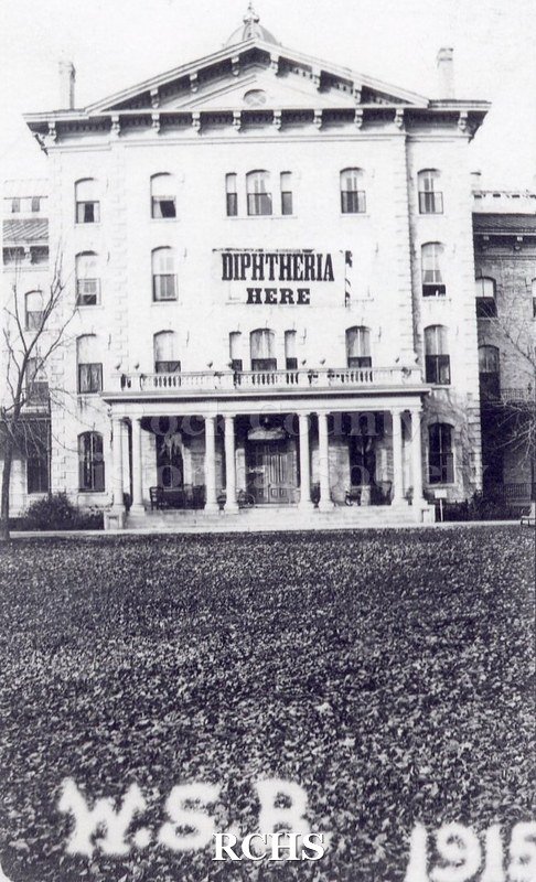 Black and white photograph of the Wisconsin School for the Blind, 1915. Shows the front facade with a large sign: "Diptheria Here" on the third floor.