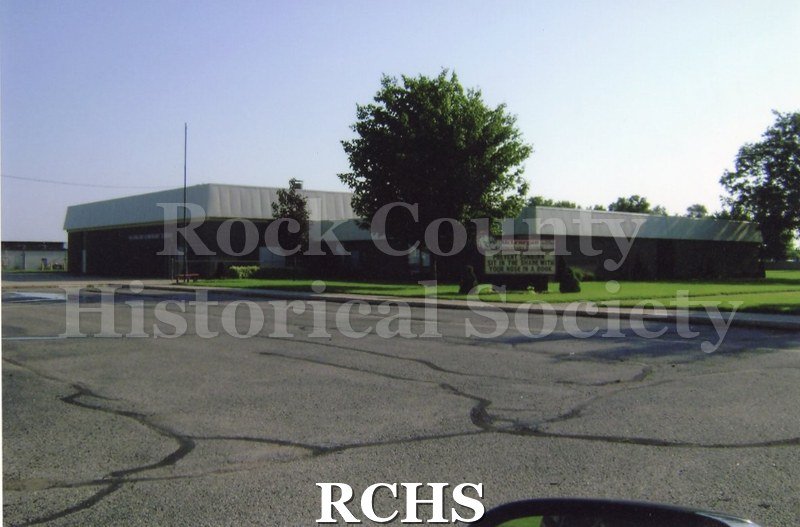 Colored photograph of McLenegan Elementary School, 2639 Sunshine Ln., Beloit. Dark brick building.