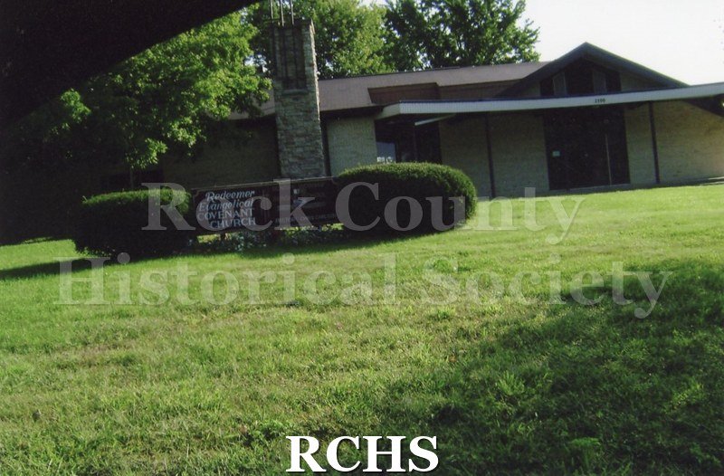 Colored photograph of Redeemer Evangelical Covenant Church, 2500 Prairie Ave., Beloit. Light color brick with a dark brown trim. One story.
