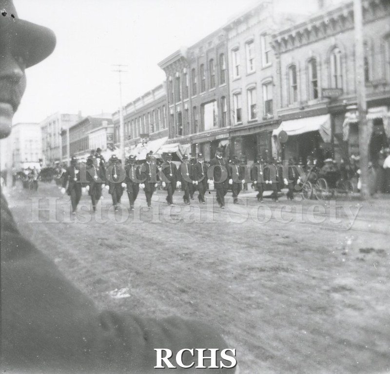 Black and white photograph of members of the Janesville Police Department marching in the Janesville 4th of July parade.