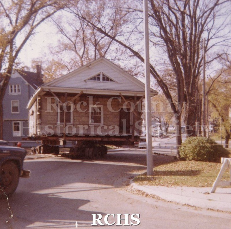 Color photo of the Stone House on skids on the road to the Tallman Restorations.