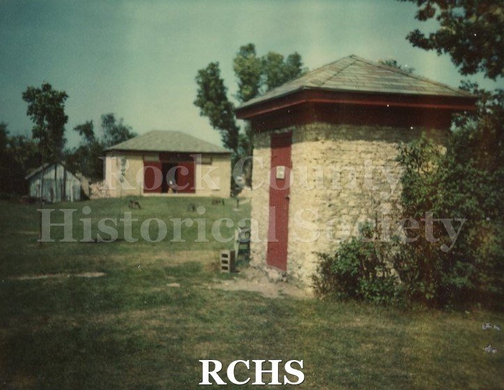 Color photo of the smoke house and barn on the Bartlett Museum grounds.