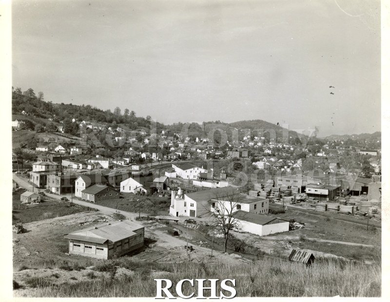 Black and white photograph of the Ossit Church Furniture Co., Bluefield, VA. Shows a factory with houses around it.
