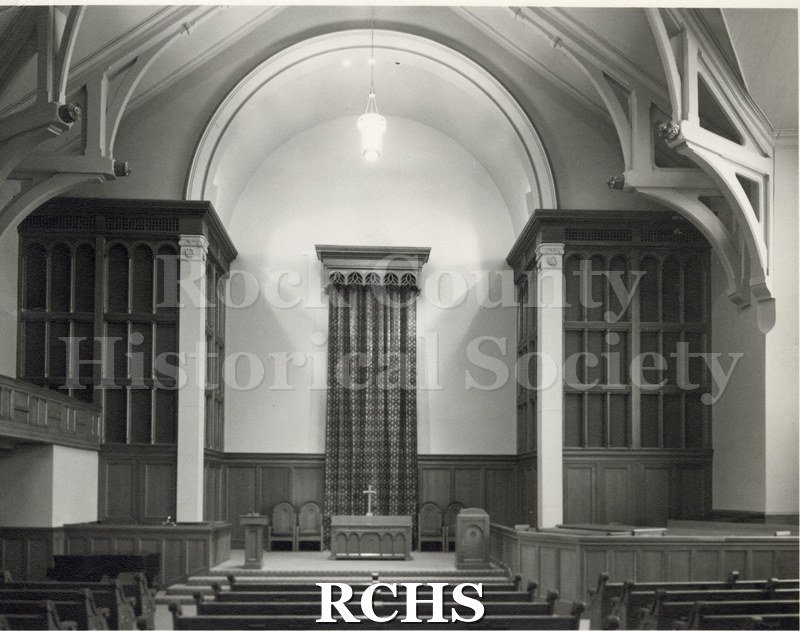 Black and white photograph of the interior of First Baptist Church, Lansing, MI, featuring the altar area. There is a tall drapery in back of the altar.
