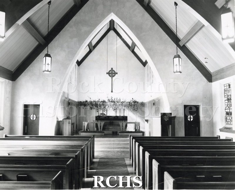 Black and white photograph of Immanuel Lutheran, Wausau, WI. Shows the interior of the church, looking toward the altar from behind the pews.