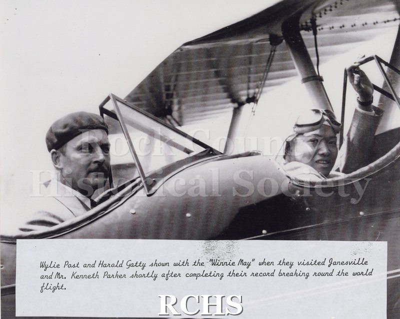 Black and white photograph of Wylie Post and Harld Gatty in the "Winnie May" during their visit to Janesville.