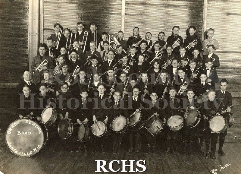 Black and white photograph of the Grade School Band, Janesville, Wisconsin. Shows band members with instruments.