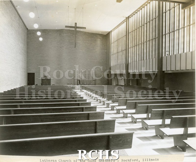 Black and white photograph of the interior of Lutheran Church of the Good Shepherd, Rockford, IL, showing a row of pews leading up to a plain altar.