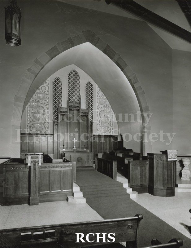 Black and white photograph of the interior of Presbyterian Church, Monmouth, IL, showing the altar area. There is elaborate paneling behind the altar.