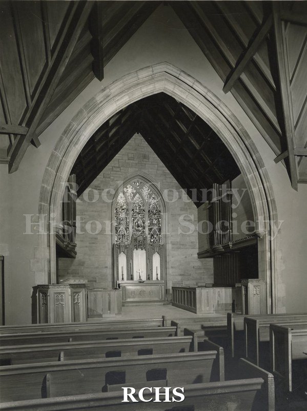Black and white photograph of the interior of an unidentified church, showing pews leading up to the altar area.