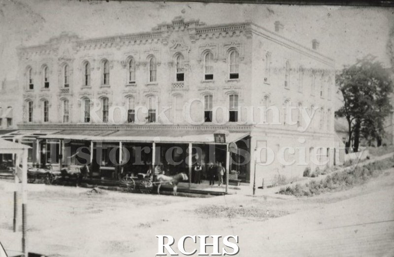 Black and white photograph of Fathers' liquorstore, a three story building with a porch extending over the first floor.