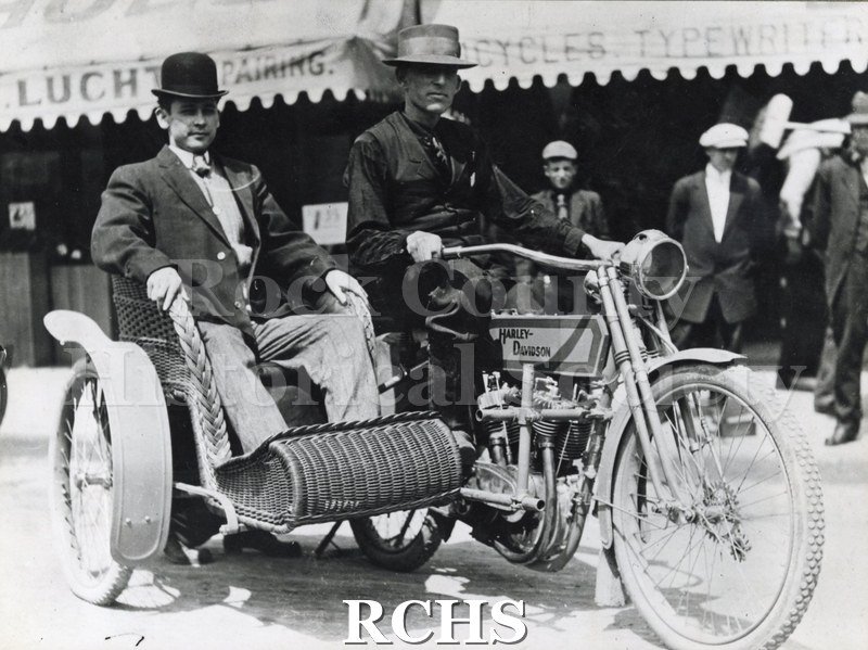 Black and white photograph of H. H.McDaniels and friend, posing in a Harley-Davidson motocycle with a side car.