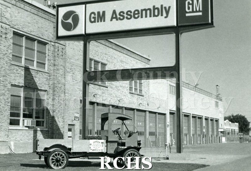 Black and white photograph of Samson tractor posed in front of the GM Assembly plant.