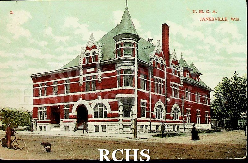 Postcard. Colored postcard of the YMCA building on W. Milwaukee St. in Janesville. Photo for the postcard was taken across the street from the red brick building.