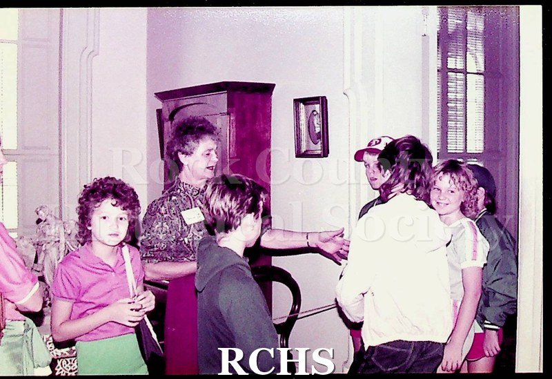 Colored photograph of unidentified school children visiting the Tallman House.