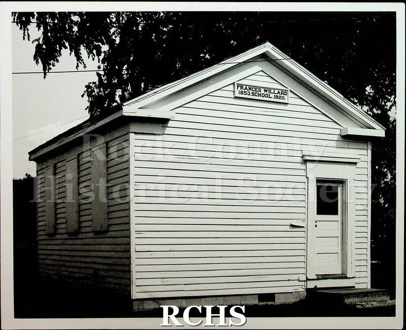 Black and white photograph of Frances Willard school. There is a sign over the door: "Frances Willard 1853 School 1920".