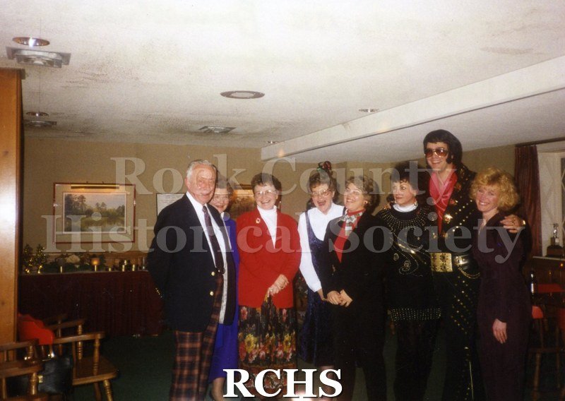 Colored photograph of Maurice Montgomery, Collette Butler, Chris Waga, Joyce Dodge, Laurel Fant, Judy Meisner, Val Crofts impersonating Elvis Presley, and Dana.