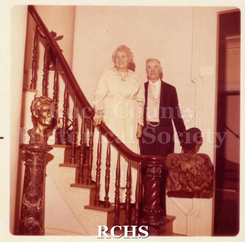 Colored photograph of Mr. & Mrs. Stark standing on the Tallman House staircase.