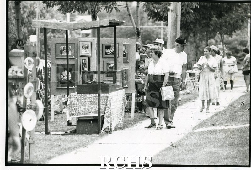Black and white photograph of the 1983 Tallman Festival. Shows people on the grounds of the Tallman House looking at exhibits.