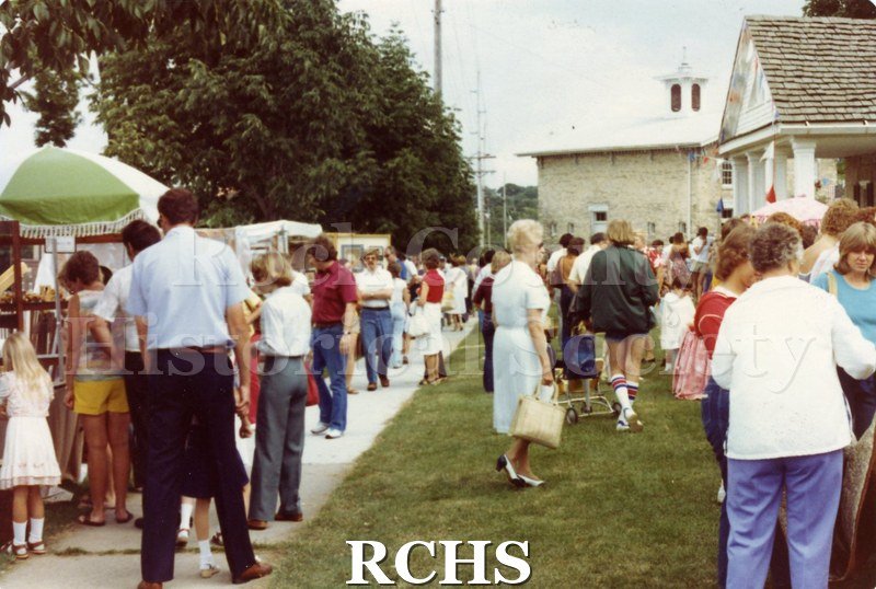 Colored photograph of people strolling the grounds at the Tallman Arts Festival.