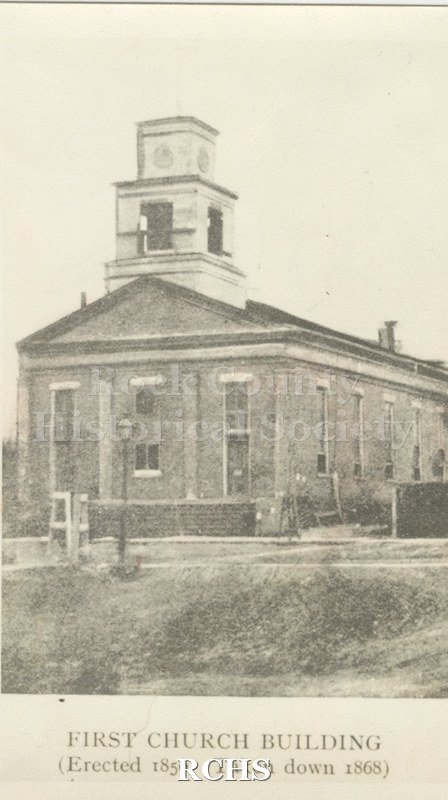 Black and white photograph of First Church Building. Shows a two story brick building with a bell tower on top. On bottom: "First Church Building (Erected 1850.