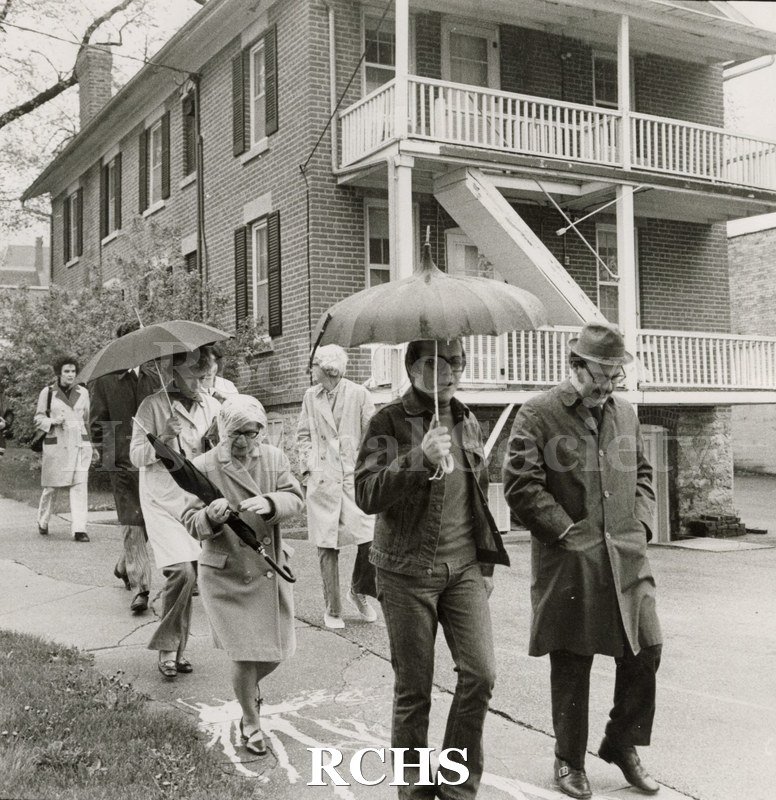Black and white photograph of Richard Hartung and others on a walking tour of downtown Janesville.