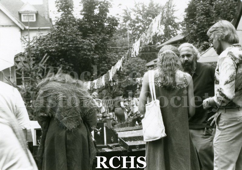 Black and white photograph of people standing around an exhibit of jewelry at the Tallman Arts Exhibit.