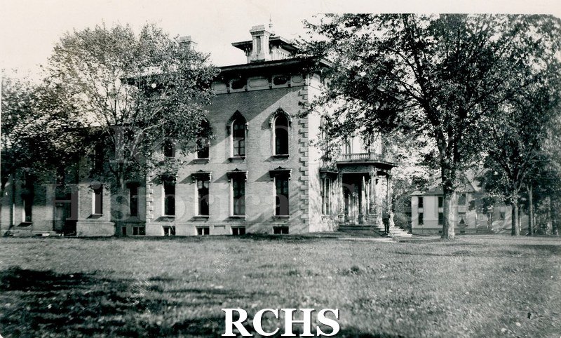 Black and white photograph of the Tallman House from the side. Shows lawn and trees.