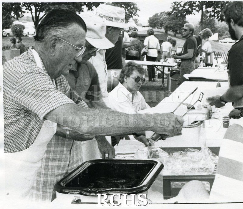 Black and white photograph of the 1984 Arts Festival. Shows volunteers serving food at the Arts Festival.