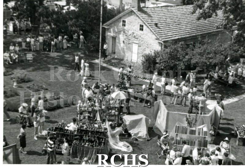 Black and white photograph of people on the grounds of the Tallman House behind the Stone House. Photo is taken from above.