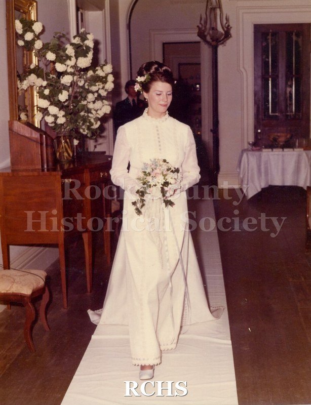 Color photo of bride walking on the white runner.