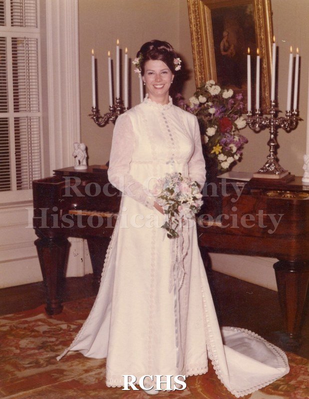 Historic image of Color potograph of bride standing near the piano.