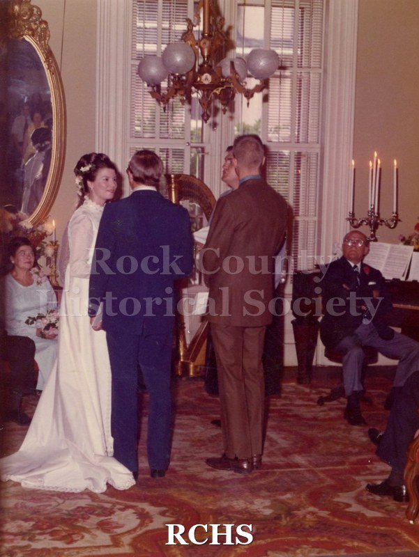 Historic image of Color photogrpah of bride and groom saying their vows.