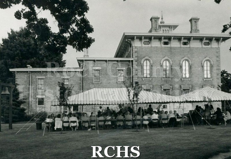Black and white photograph of SHSW Annual Meeting taking place on the Tallman grounds. People are seated under a large tent.