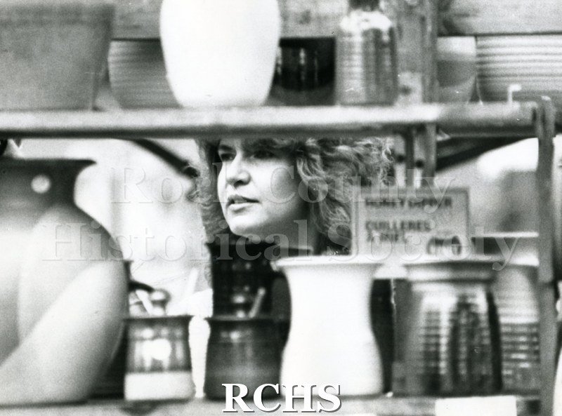 Black and white photograph of the 1983 Tallman Festival. Shows a woman looking at mugs.