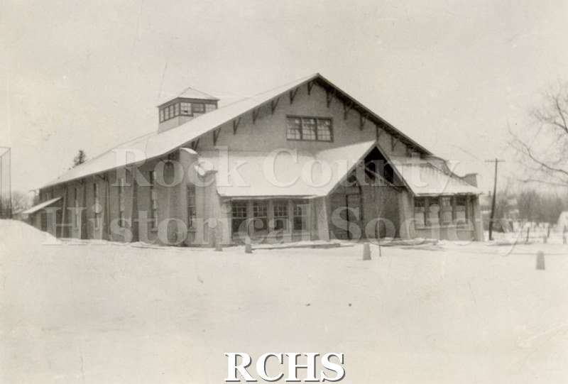 Black and white photograph of Milton College gym. Shows a two story building with a large porch in front.