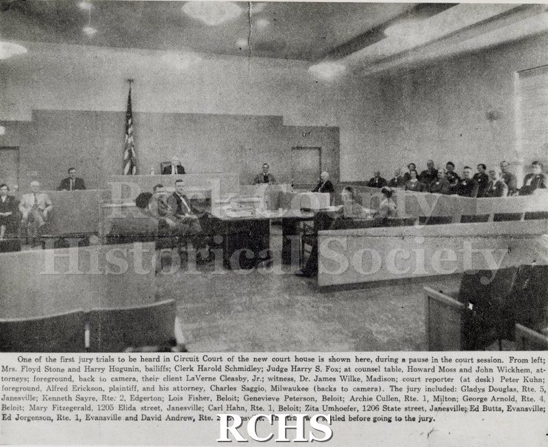 Black and white photograph of a Jury Trial. This is a newspaper article showing a trial in progress.