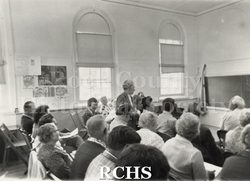 Black and white photograph of the South Central Regional meeting . Shows several men and women in a meeting, sitting in chairs.