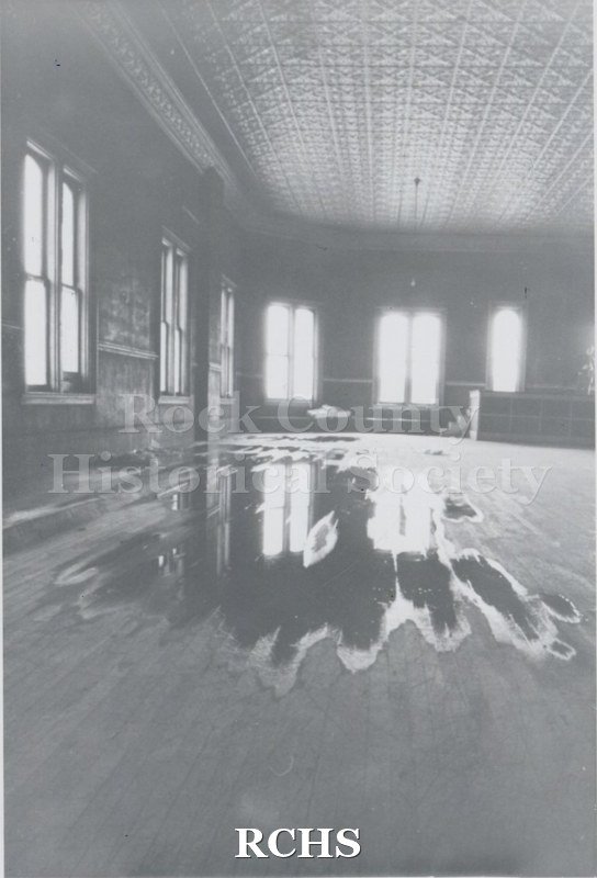 Black and white photograph of Myers Block-Old Armory, Janesville, WI, interior view, showing ceiling and arched windows.