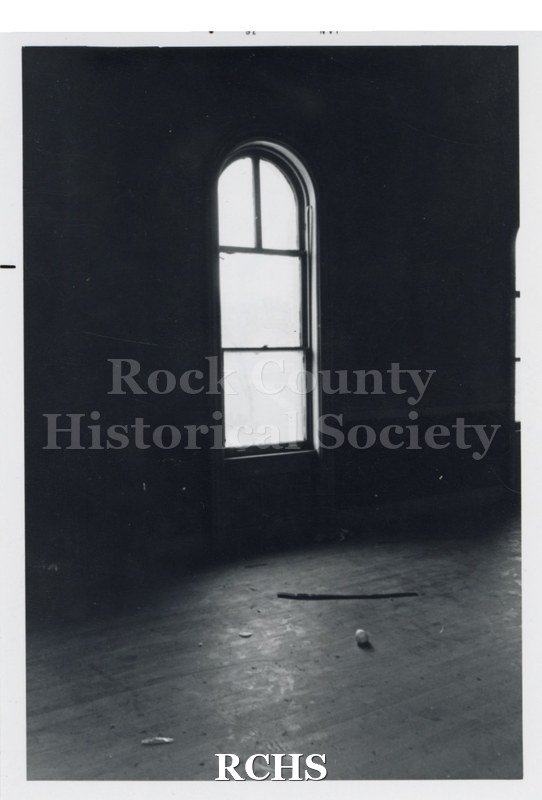 Black and white photograph of the Court Street Methodist Church. Shows an arched window with a ball on the floor.
