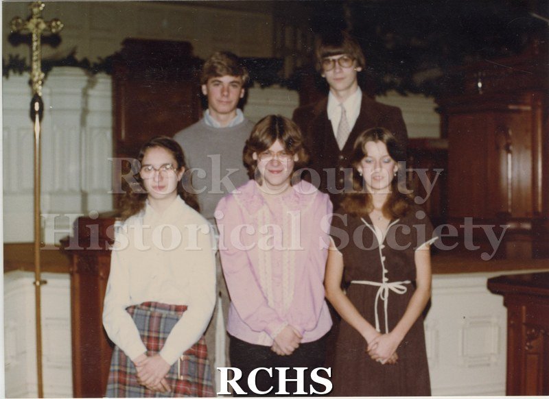 Color photo of the Faith Formation Class of 1981. Shows two boys and three girls standing in front of the altar of a church.