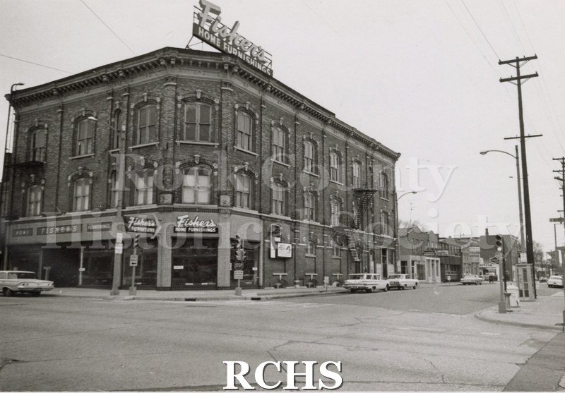 Black and white photograph of Fisher's Home Furnishings, Janesville, WI, a three story building on an intersection.