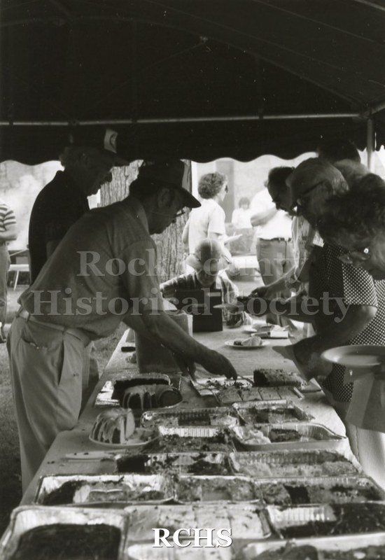 Black and white photograph of volunteers serving food at the Arts Festival.
