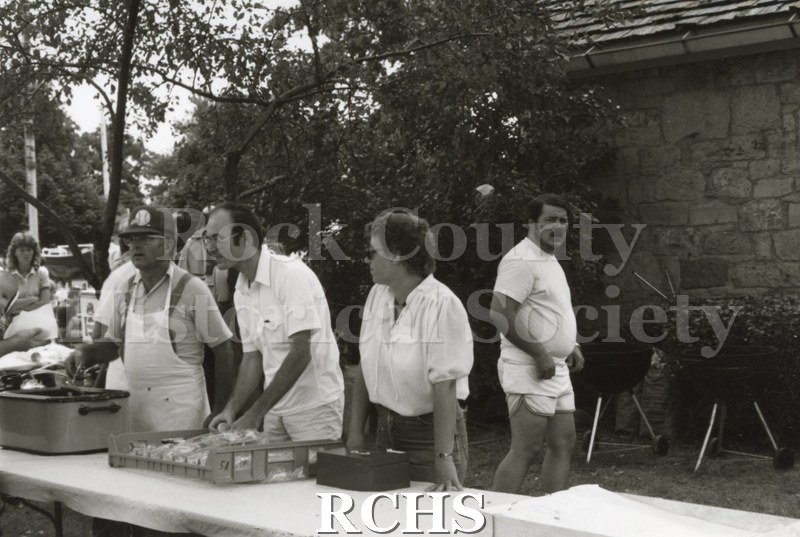 Black and white photograph of volunteers serving food at the Arts Festival.