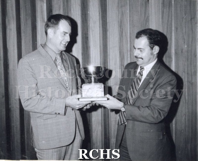 Black and white photograph of Lloyd Hornbostel, Jr. presenting a trophy to Richard Hartung.